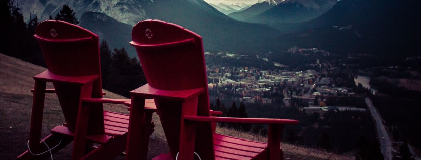 Two red chairs side by side at the top of the Mt. Norquay viewpoint